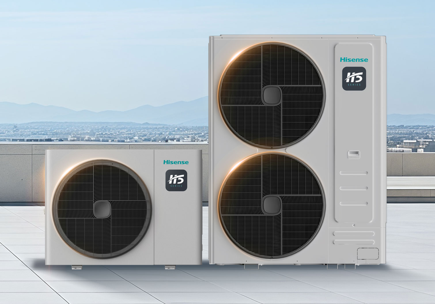 Zwei Hisense H5 Series Außengeräte für Klimaanlagen auf einer Dachterrasse – ein kleineres Gerät mit einem großen Ventilator und ein größeres Modell mit zwei großen Lüftern, beide in hellem Gehäuse vor Stadt- und Bergkulisse.